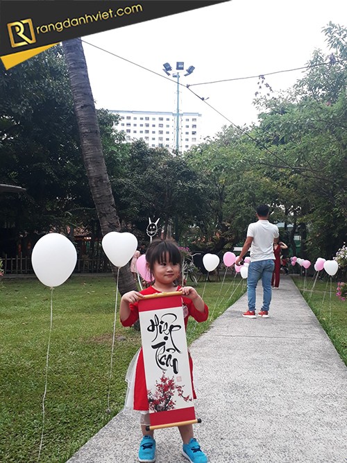 bé thiếu nhi nhận chữ từ ông đồ